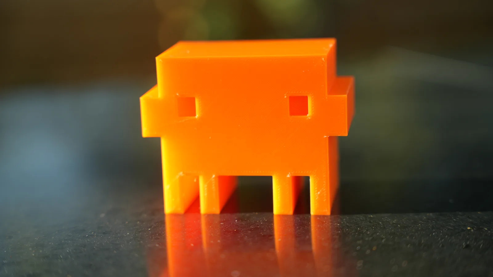 The first Clawd that printed all the way through, on a stone table at sunset